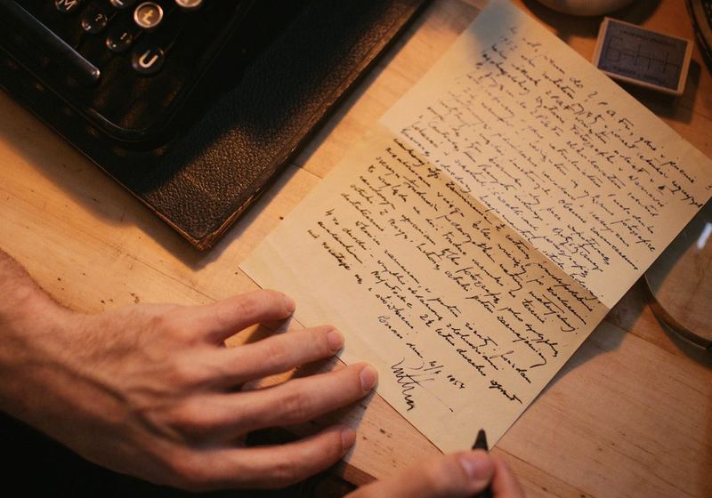 A vintage typewriter beside a handwritten letter